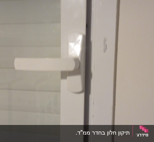 ידית לבנה על תריס חלון לבן